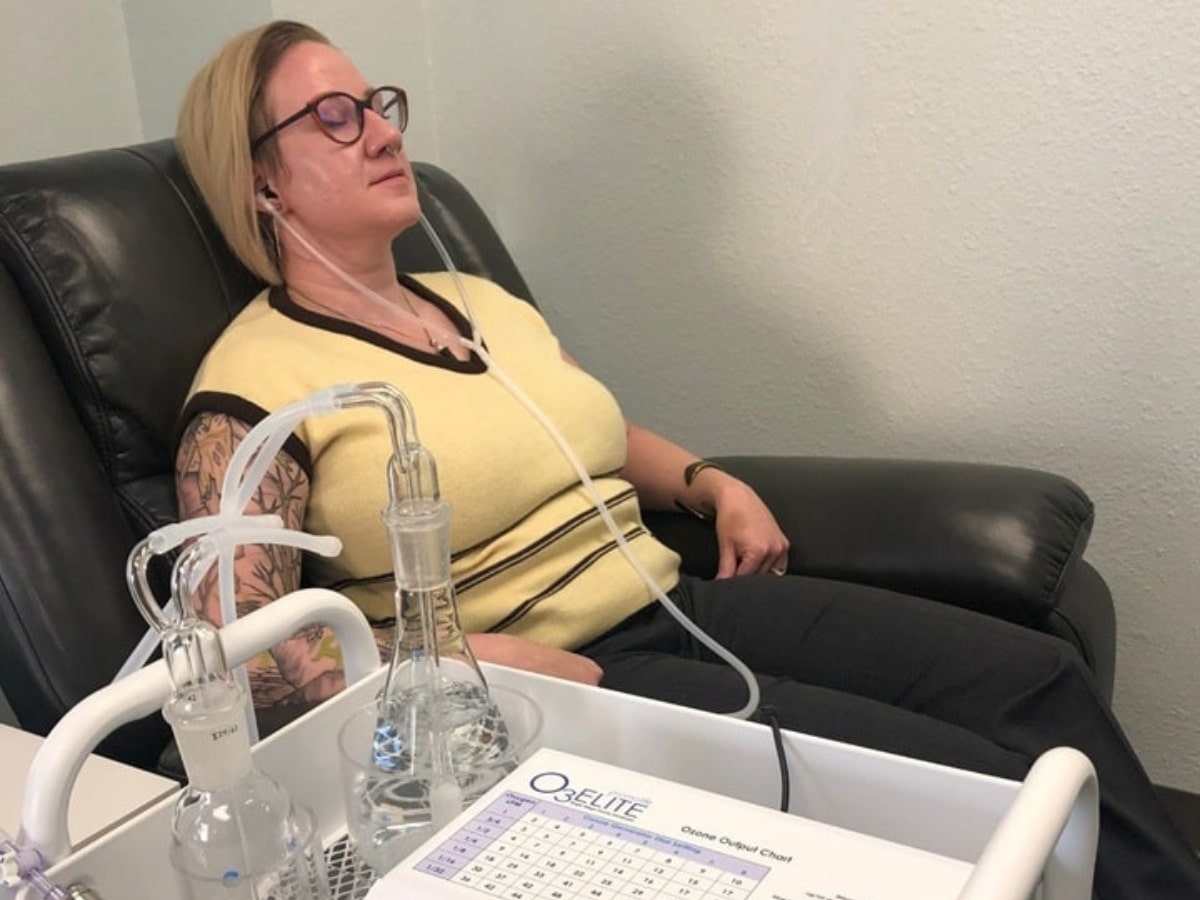 Patient relaxing in a recliner while receiving ozone ear therapy in a clinical setting at Lim Acupuncture Clinic.