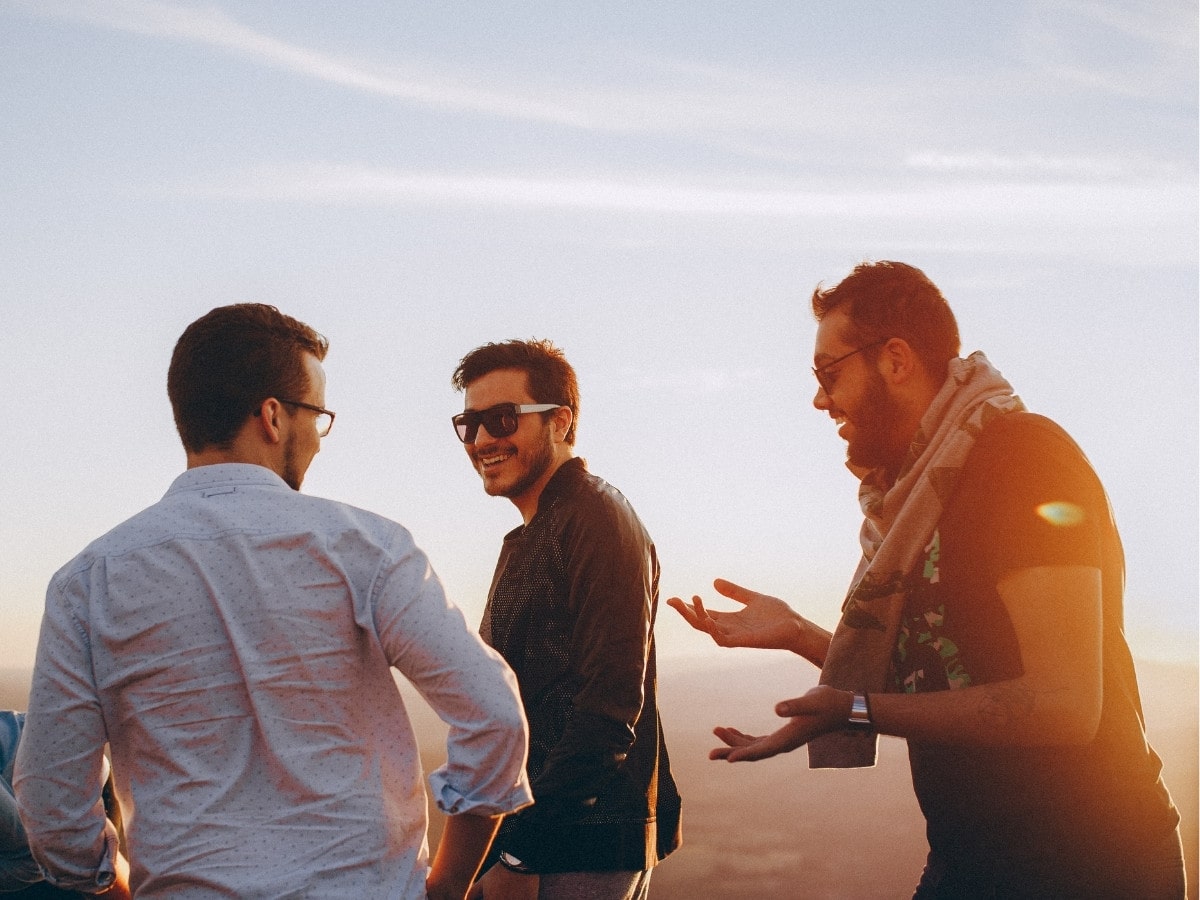 Group of men laughing together outdoors, promoting awareness of men’s fertility health and acupuncture support for reproductive wellness.