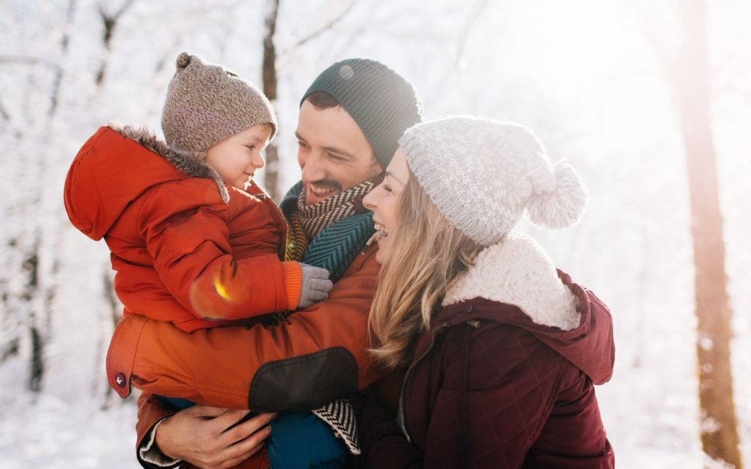 Family enjoying a sunny winter day outdoors, representing immune support and acupuncture for cold and flu relief during winter.