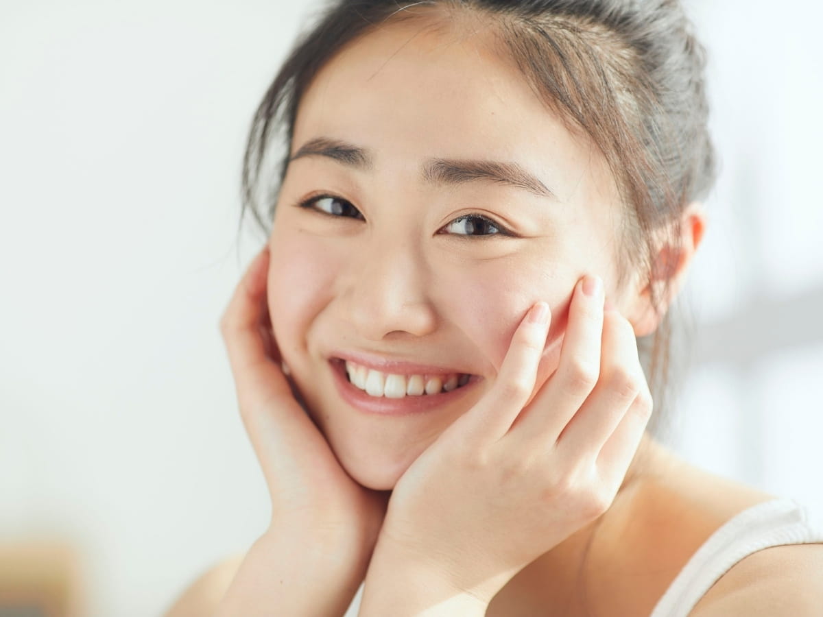 A women smiling after a day recovery from her microneedling treatment.
