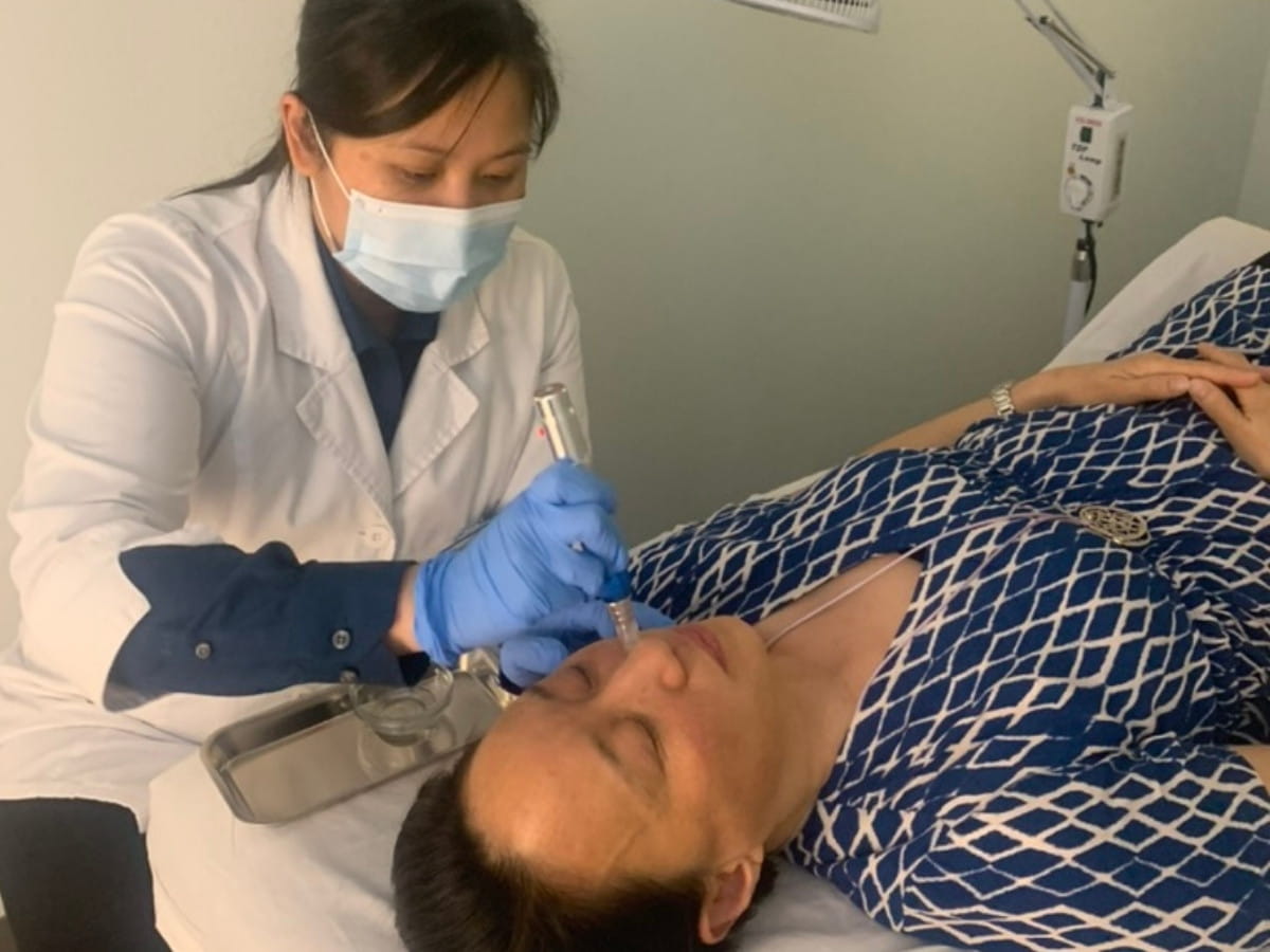Dr. Fung Fung Lim performing a facial microneedling treatment on a real patient.