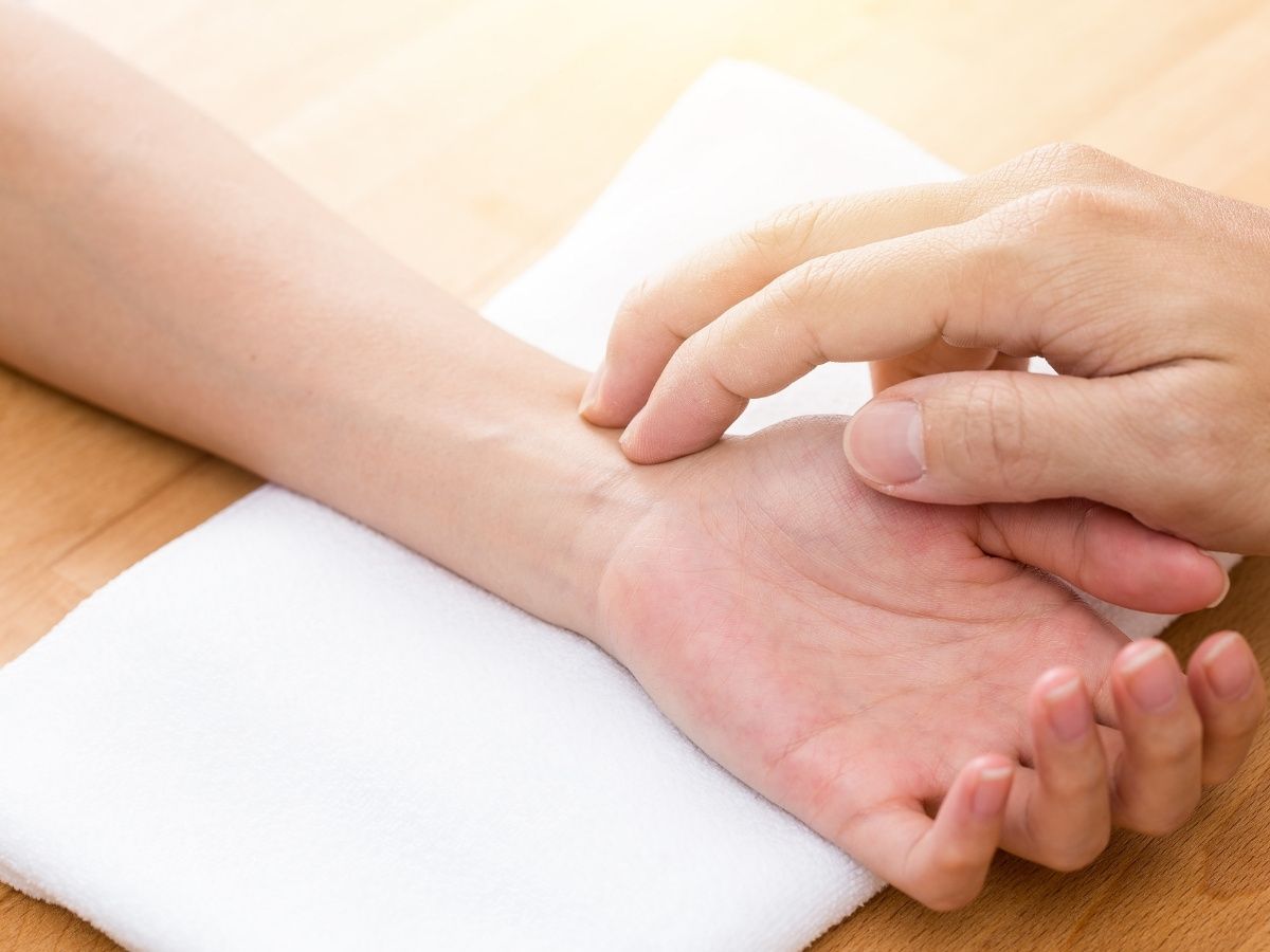 A licensed acupuncturist feeling the radial and kidney pulses as part of a Traditional Chinese Medicine assessment.