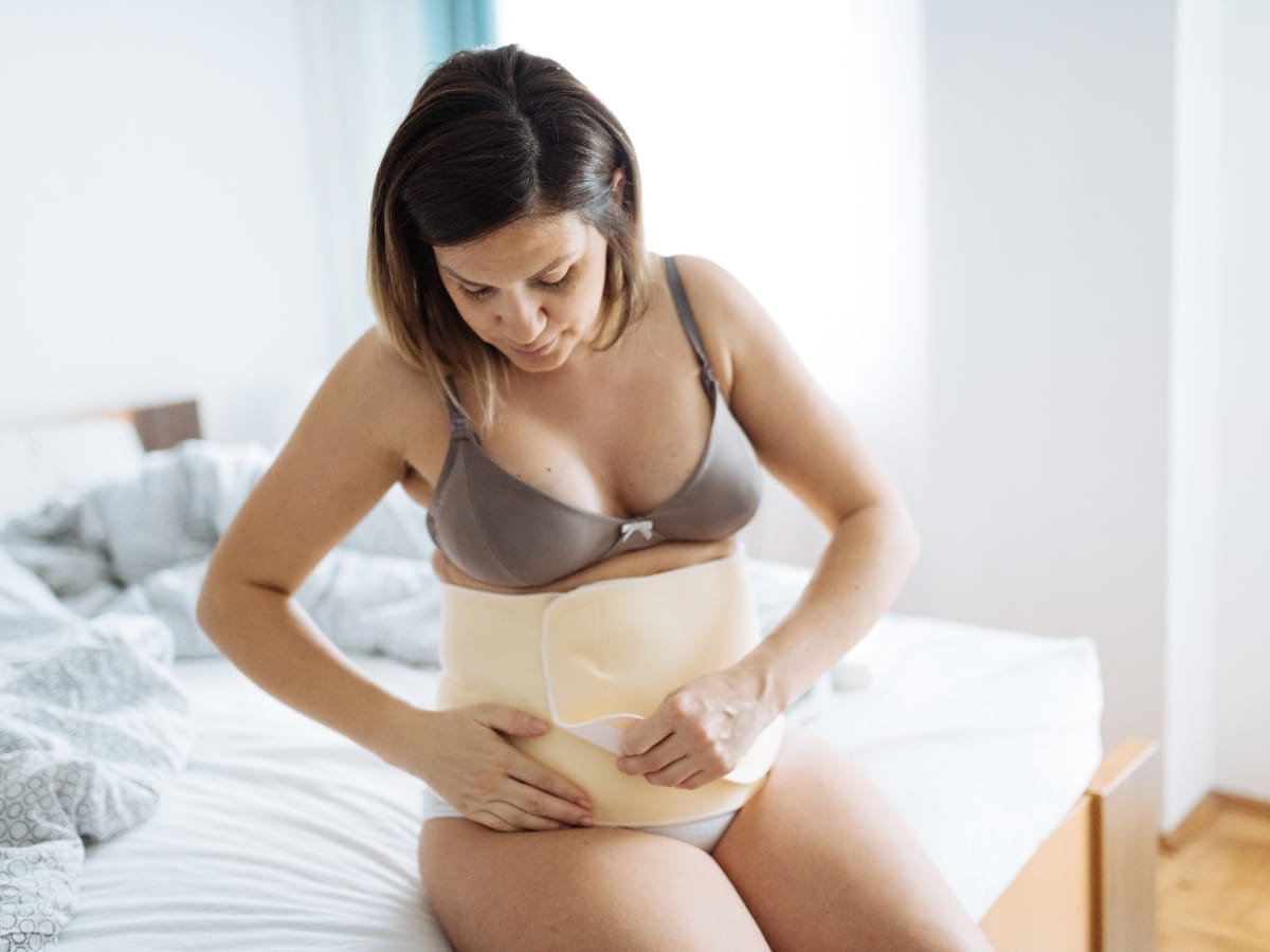 A postpartum women wrapping her abdominal area as part of her postpartum care.