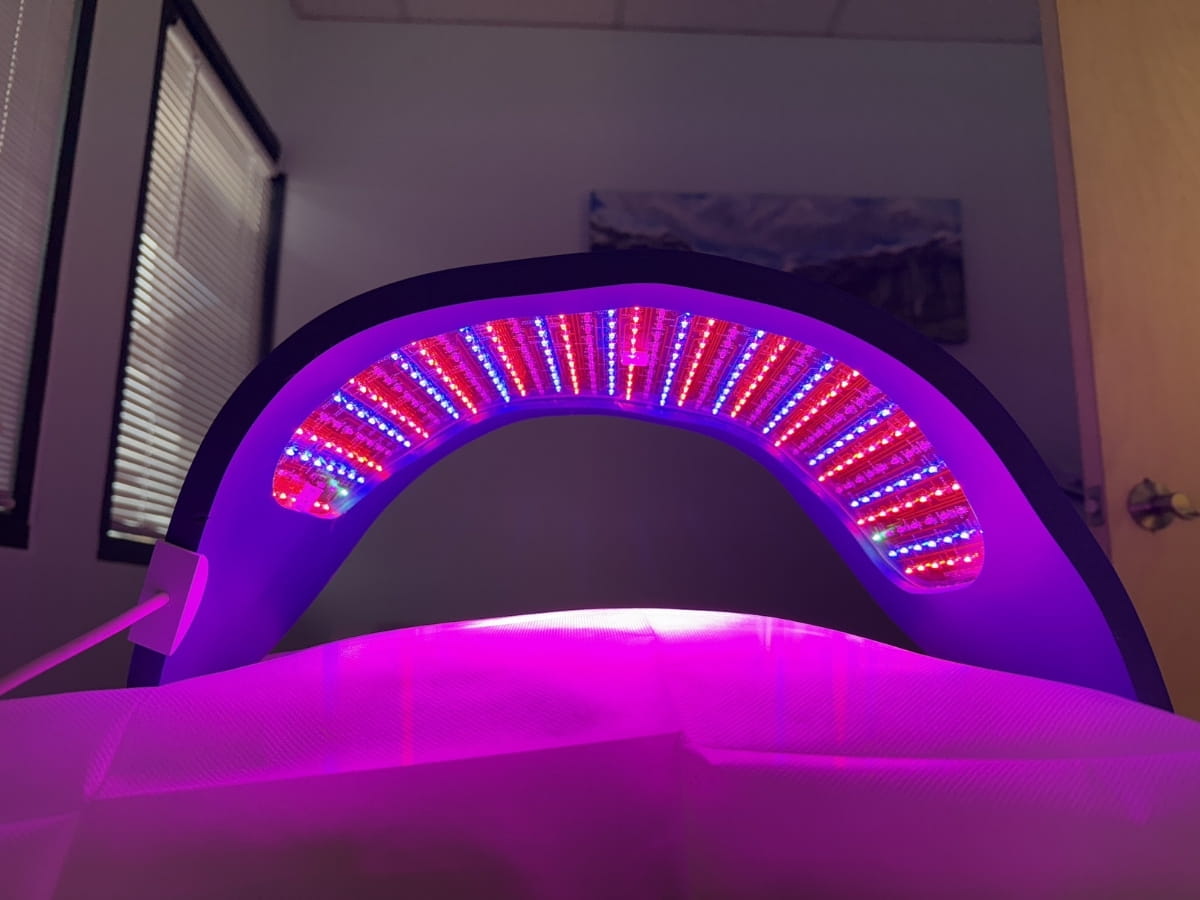 Celluma LED Light Therapy device on a treatment table with lights on.