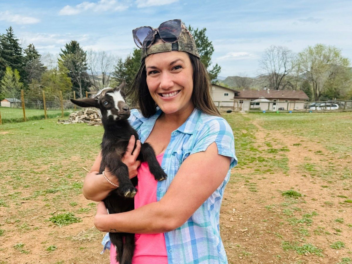 A candid photo of licensed acupuncturist Brenna Lewis holding a cute animal.