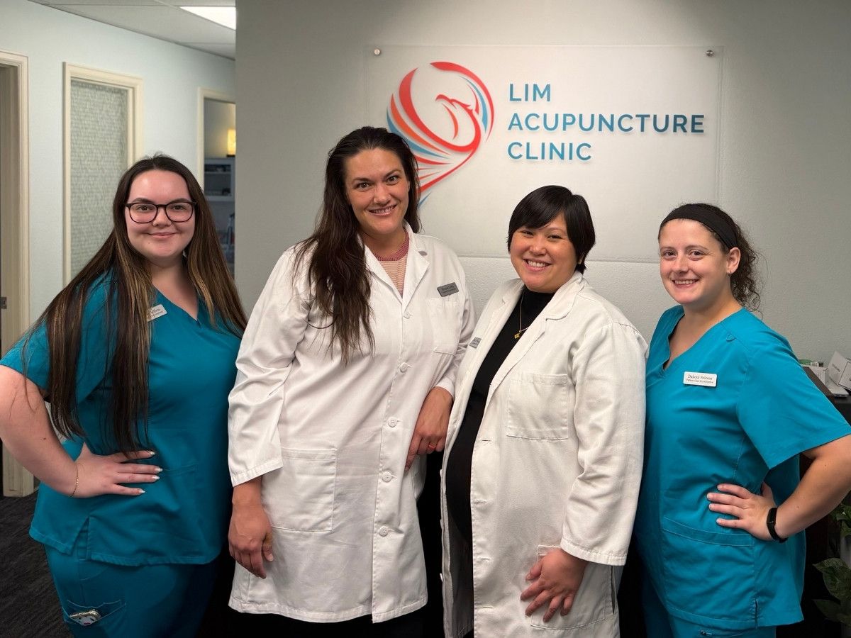 A group photo of Andrea, Brenna Lewis, Dr. Fung Fung Lim, and Dakota in the lobby of Lim Acupuncture Clinic.